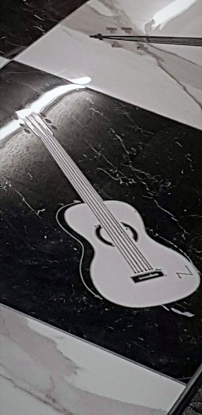 Close-up of a white guitar inlaid in black marble